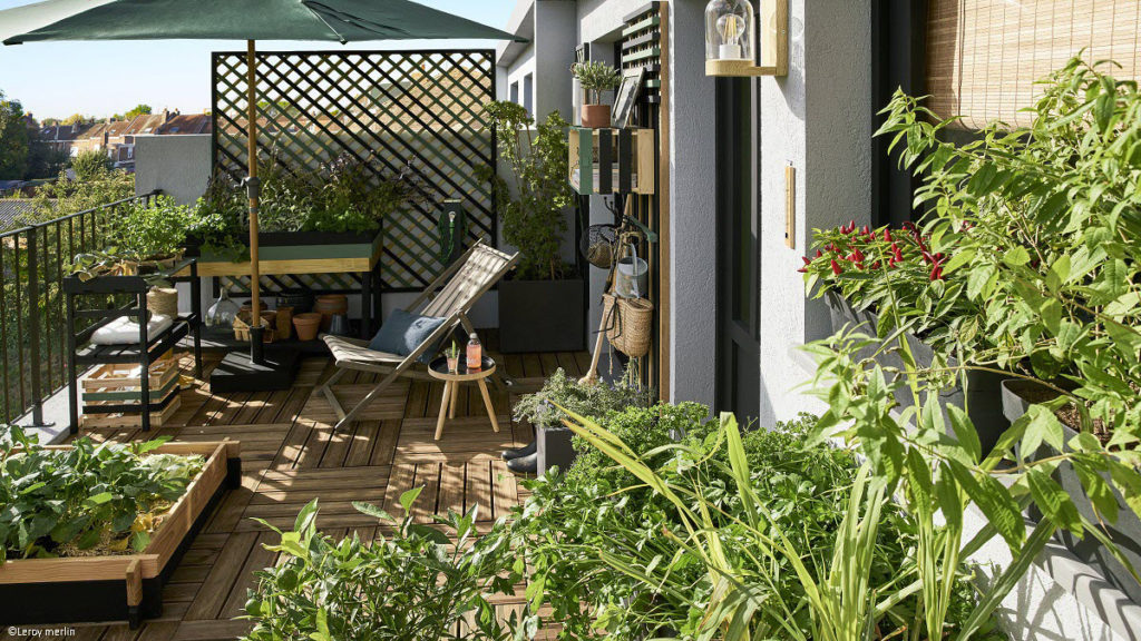 une terrasse en bois avec une chilienne et des plantes
